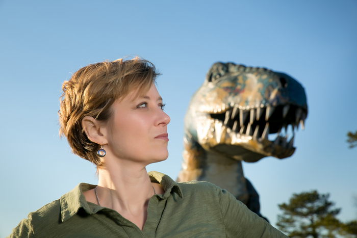 Picture of Erin Beatu facing right with a T-Rex statue in background
